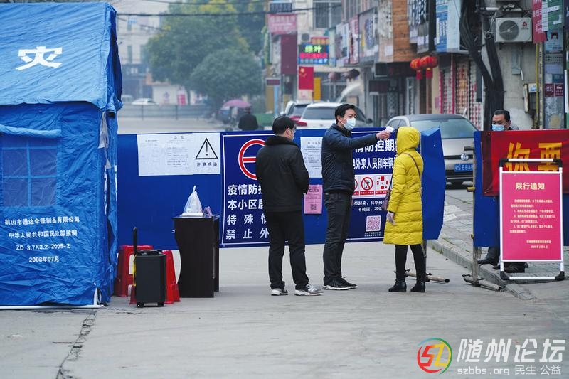 曾都區(qū)西城防疫工作人員給出入人員測體溫